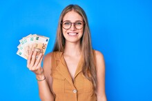 Young Blonde Girl Holding Euro Banknotes Smiling With A Happy And Cool Smile On Face. Showing Teeth.