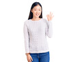 © Krakenimages.com - Young beautiful chinese woman wearing casual sweater smiling positive doing ok sign with hand and fingers. successful expression.