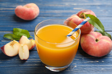 Natural peach juice and fresh fruits on blue wooden table, closeup