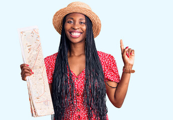 Canvas Print - Young african american woman wearing summer hat holding city map surprised with an idea or question pointing finger with happy face, number one