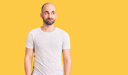 Young handsome man wearing casual t shirt smiling looking to the side and staring away thinking.