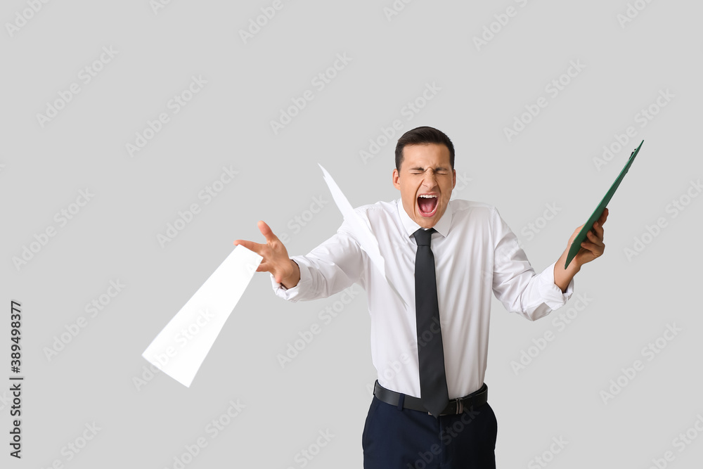 Stressed young businessman on light background