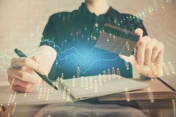 Poster - Double exposure of man hands holding a credit card and Forex graph drawing. Stock trading and digital fintech in Internet E-commerce concept.