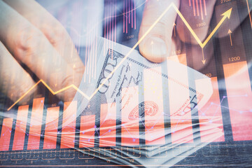 Multi exposure of forex graph drawing hologram and USA dollars bills and man hands. Technical Analysis concept.