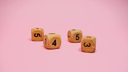 Wooden dice on pink background