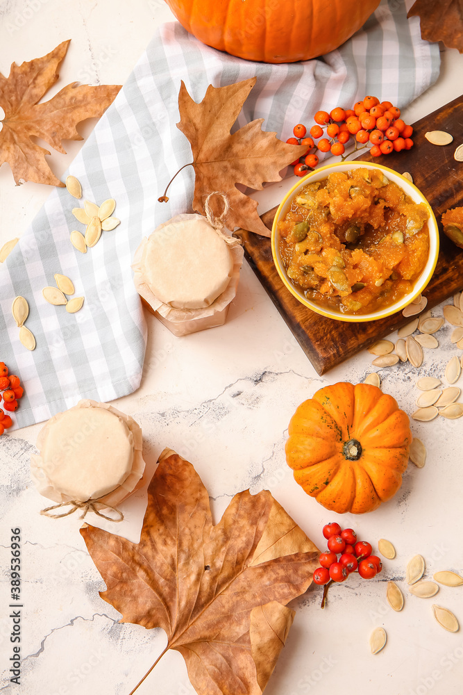 Autumn composition with tasty pumpkin jam on white background