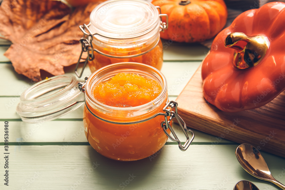 Jars of tasty pumpkin jam on table