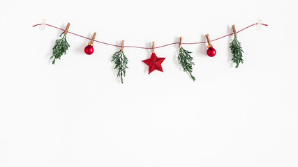 christmas composition. garland made of red balls and fir tree branches on white background. christma
