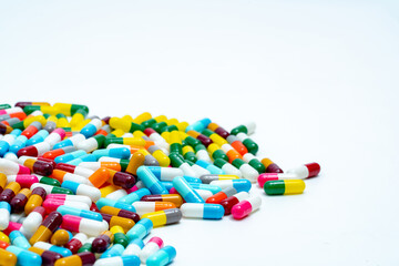 Canvas Print - Selective focus on pile of multi-colored antibiotic capsule pills. Antimicrobial capsule pills on white background. Antibiotic resistance concept. Pharmacy drugstore products. Pharmaceutical industry.