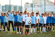 © Roman - portrait of confident team of young football players posing at camera, athletic boys in uniform going to play football or soccer. in stadium