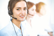 © Iryna - Call center operators. Focus on beautiful business woman using headset