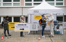 People waiting in covid-19 testing center outdoors on street, coronavirus concept.