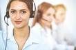 © rogerphoto - Call center. Focus on beautiful business woman in headset