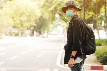 Wall Mural - Asian travelers man in the street with medical face mask to protection the Covid-19, new normal lifestyle