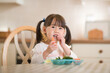 © M-image - young girl eating fresh green vegetables against real kitchen background
