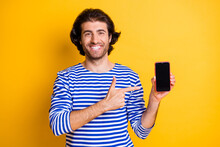 Photo Of Positive Guy Point Finger Smartphone Recommend Advert Wear Nautical Vest Isolated Over Bright Yellow Color Background