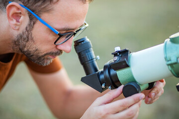 Wall Mural - amateur astronomer looking at the sky with a telescope.