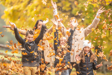 Foliage flying in the air by a young family in outdoor fall fun