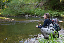 Young Woman Learning To Fly Fishing With A Profesional Guide