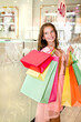 © svetamart - Beautiful happy smiling little girl child is holding shopping bags in shopping mall.