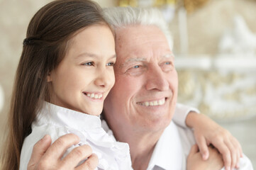 Poster - Portrait of happy elderly man with cute granddaughter