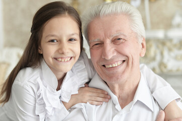 Poster - Portrait of happy elderly man with cute granddaughter