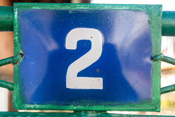 Weathered grunge square metal enameled plate of number of street address with number 2