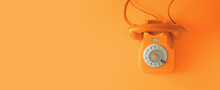 An Orange Vintage Dial Telephone With Orange Background.
