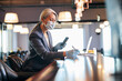 © Svitlana - Businesswoman in medical mask using cellphone and taking notes