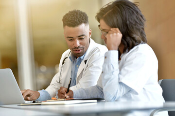 Wall Mural - Young doctors working on laptop at the hospital