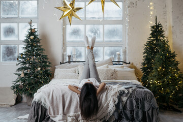 Wall Mural - Young adult woman spending christmas holidays at home