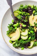 Canvas Print - Green and purple kale salad with edamame beans, avocado and cucumber, top view. Healthy vegan food concept.