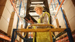 © Gorodenkoff - Professional Female Worker Wearing Hard Hat Lifts Herself on Aerial Work Platform to Check Stock and Inventory with Digital Tablet on the Higher Level of Retail Warehouse full of Shelves with Goods