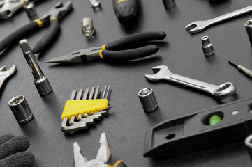 Many different tools for repair work on a black background.