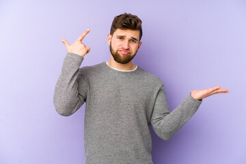 Wall Mural - Young caucasian man isolated on purple background holding and showing a product on hand.
