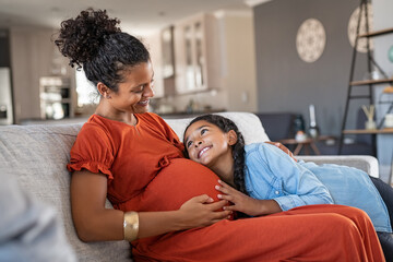 happy lovely daughter hugging pregnant mother