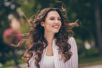 Sticker - Photo of cute optimistic young woman shiny smiling long curly hair walking park wear white striped shirt outdoors