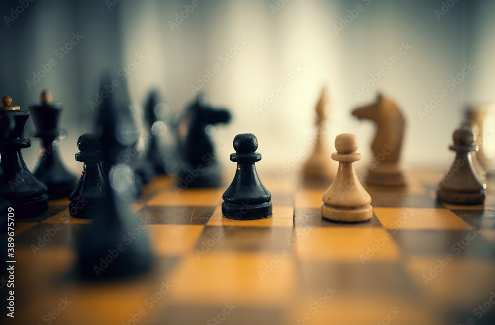 Wooden chess pieces on the chessboard. - obrazy, fototapety, plakaty 