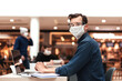 © yurolaitsalbert - young man in a protective mask and glasses sitting at a table in a cafe .