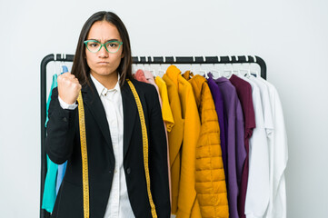 Wall Mural - Young asian designer woman isolated on white background showing fist to camera, aggressive facial expression.