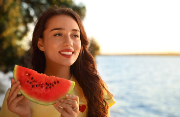 Wall Mural - Beautiful young woman with watermelon near river. Space for text