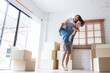 © Anatta_Tan - Asian husband Carrying and hug his wife, who were both happy and celebrating moving into a new house, with a boxs on the floor, to family and real estate concept.