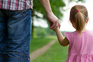 the parent holds the hand of a small child