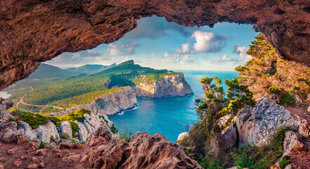Wall Mural - Astonishing summer view of Caccia cape from the small cave in the cliff. Fabulous morning scene of Sardinia island, Italy, Europe. Aerial Mediterranean seascape. Beauty of nature concept background.