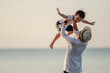 © Garun Studios - Happy family holidays. Joyful father,baby son walk with fun along edge of sunset sea surf on and beach. .Holiday Family on the beach in summer, Travel, vacation and lifestyle concept