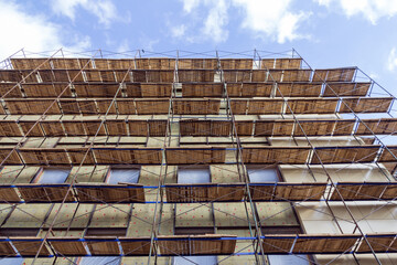 Poster - Building construction site with scaffolding. The exterior of the facade of the new building