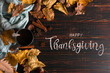 © Plutmaverick - Thanksgiving greetings. Tea in a mug, dry leaves and spices on a dark background, top view. Kaligraphic capital inscription.