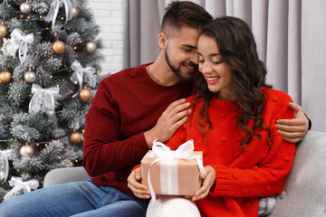 Wall Mural - Lovely couple celebrating Christmas together at home