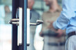 © Kostiantyn - Businessman entering at work, opening glass door in the modern office, selective focus