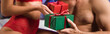 cropped view of sexy couple exchanging christmas presents at home, banner